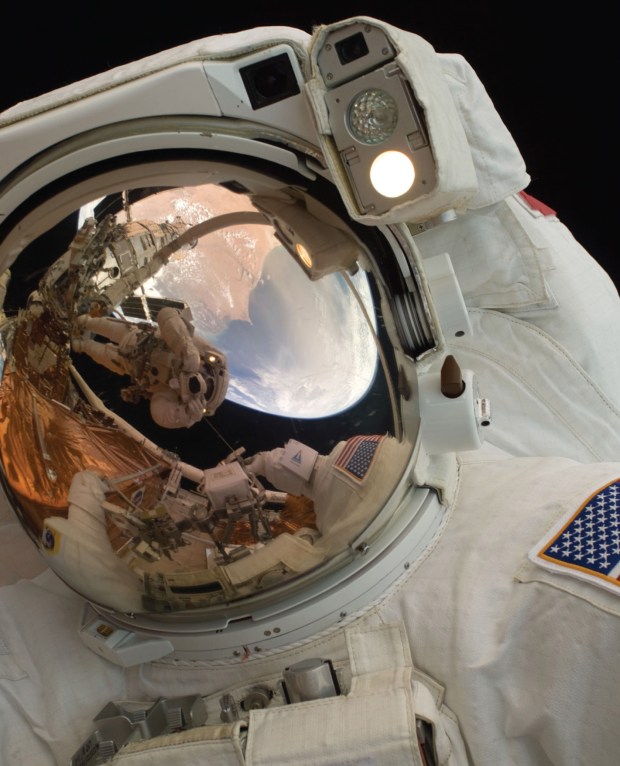 A close-up of Astronaut John Grunsfeld shows the reflection of Astronaut Andrew Feustel, perched on the robotic arm and taking the photo. The pair teamed together on three of the five spacewalks during Servicing Mission 4 in May 2009.